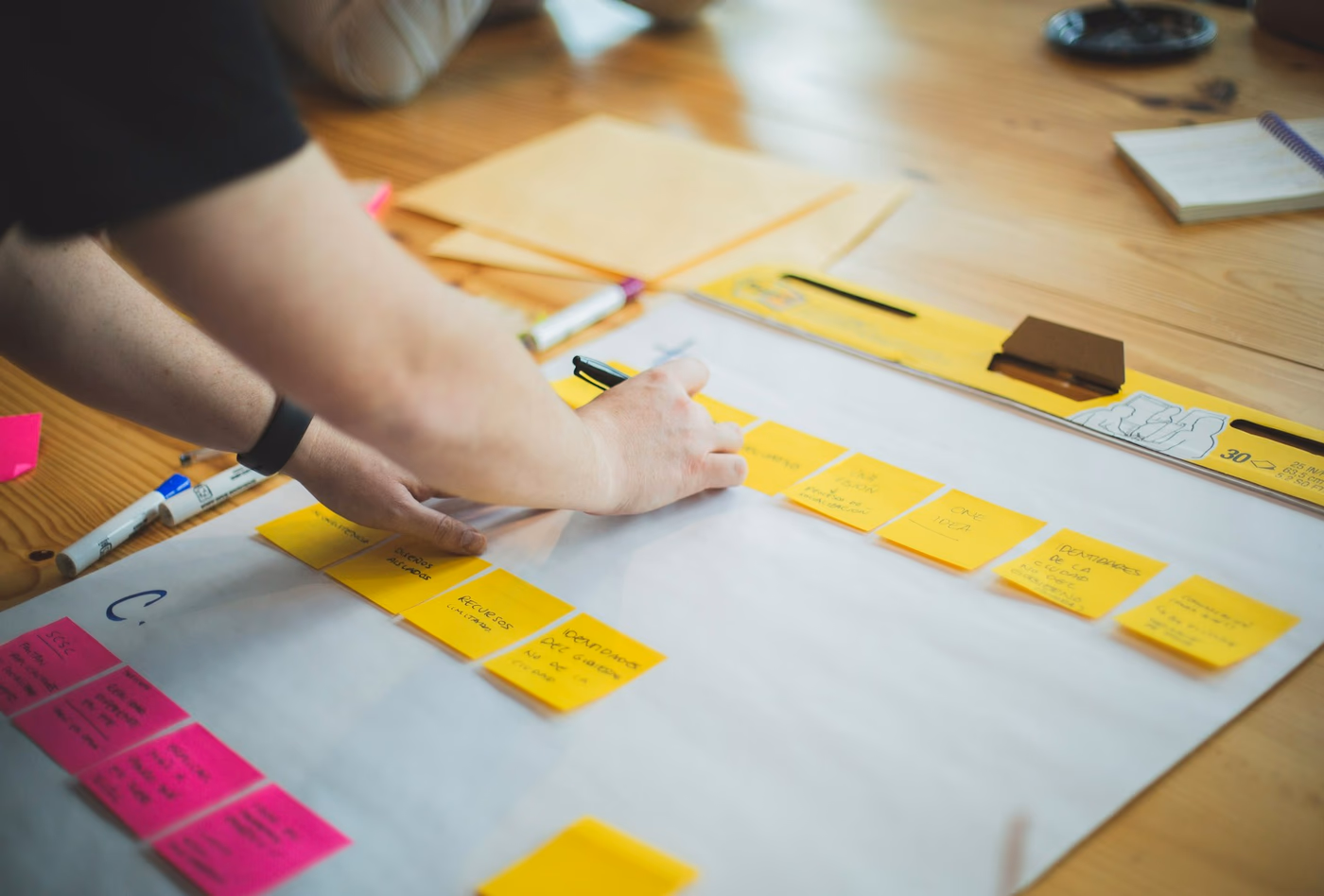 Hands writing a marketing strategy on white paper