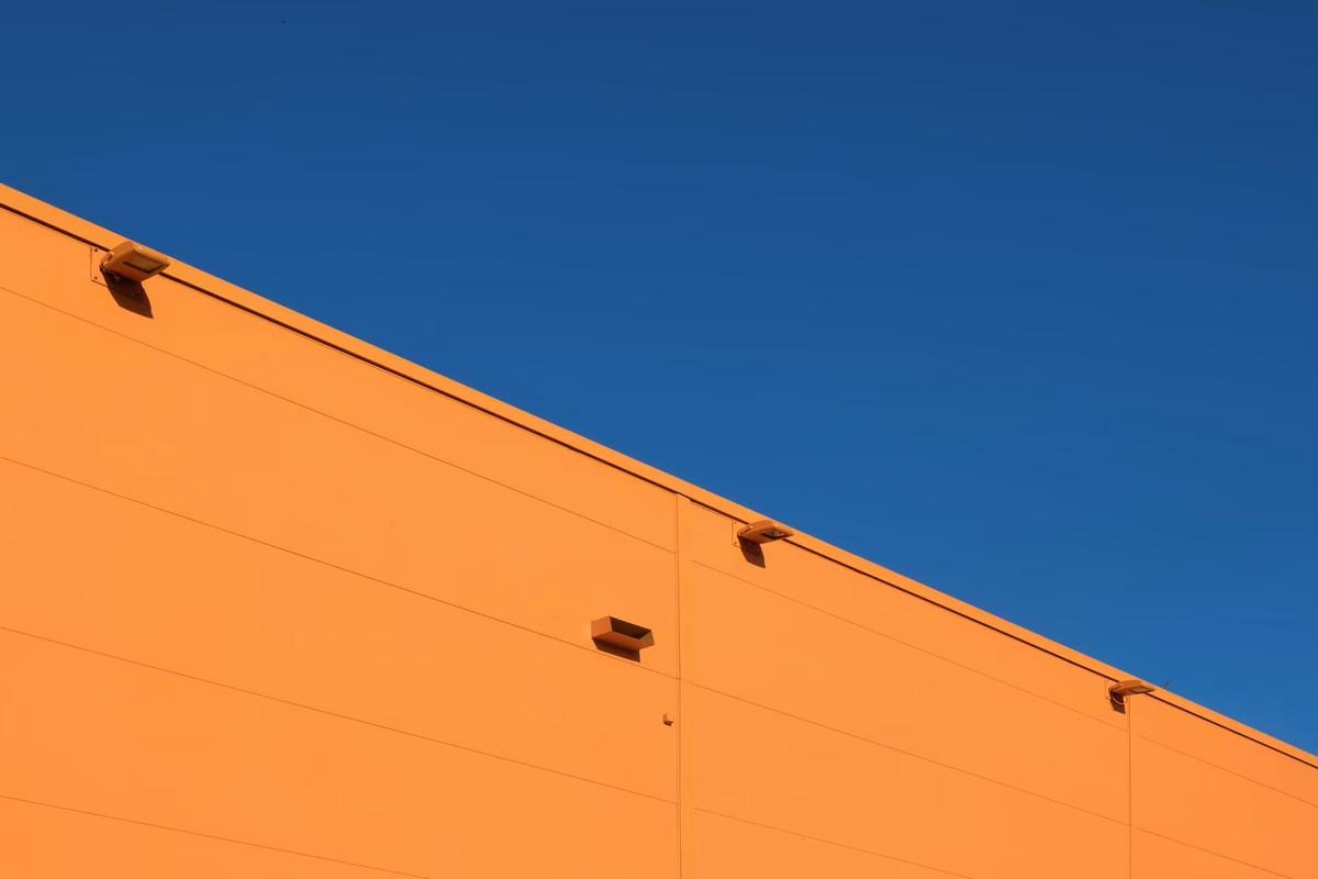 Architectural photograph of an orange concrete structure against blue sky