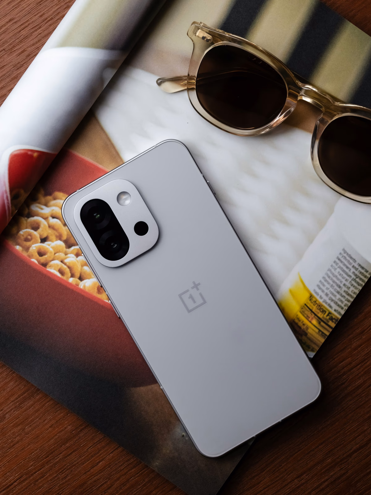 Smartphone and sunglasses resting on a printed magazine